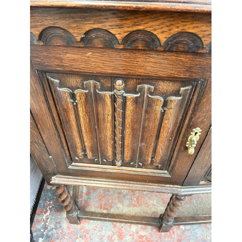 157 - A Waring & Gillow Ltd. carved oak sideboard with two drawers, two linenfold doors and barley twist s... 