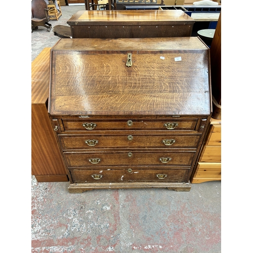 161 - A George III oak and mahogany crossbanded bureau with four drawers, fall front, fitted interior and ... 