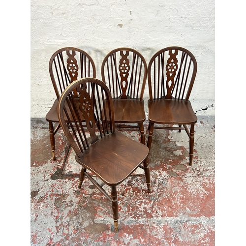 171 - A set of four beech and elm wheelback dining chairs