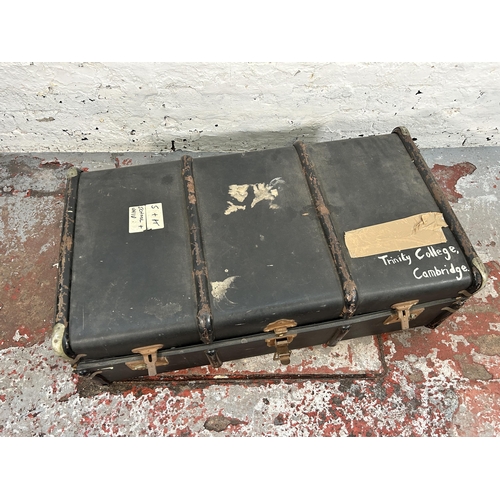 221 - An early 20th century black fibreboard and metal banded travel trunk