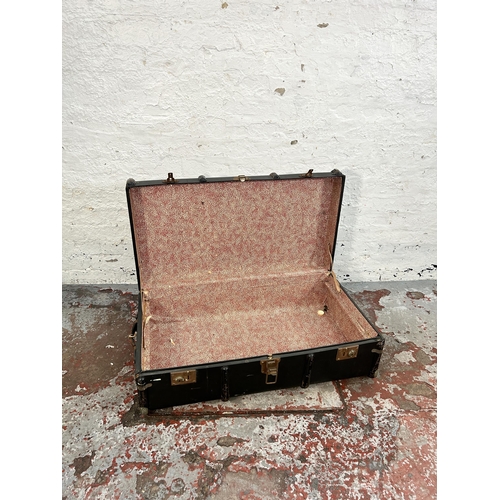 221 - An early 20th century black fibreboard and metal banded travel trunk