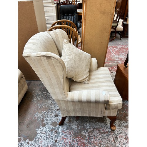 140 - A modern fabric upholstered wingback armchair with cabriole supports