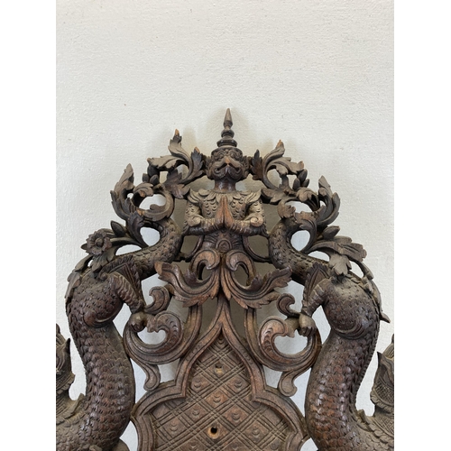 610 - A Burmese heavily carved hardwood wall bracket - approx. 56cm high x 43cm wide