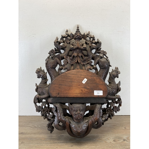 610 - A Burmese heavily carved hardwood wall bracket - approx. 56cm high x 43cm wide