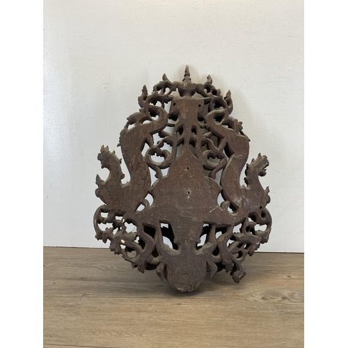 610 - A Burmese heavily carved hardwood wall bracket - approx. 56cm high x 43cm wide