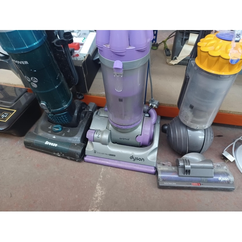 874 - Three upright bagless vacuum cleaners, one Dyson DC07, one Dyson DC40 and one Hoover