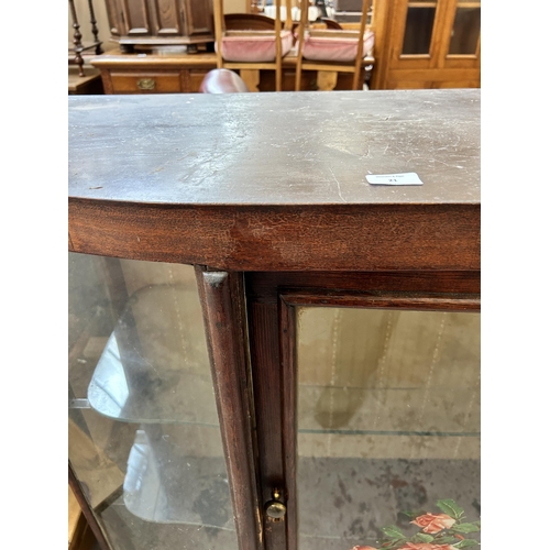 27 - A mid 20th century stained pine display cabinet with single door and two internal glass shelves