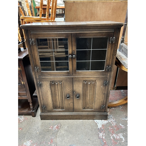 39 - A York Rose carved oak cocktail cabinet with two leaded glass doors, two linenfold doors and fitted ... 