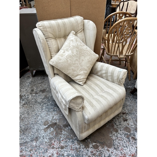 127 - A modern fabric upholstered wingback armchair on castors