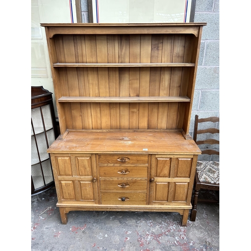 11 - An Allans of Hanley elm dresser with four drawers, two cupboard doors and upper plate rack