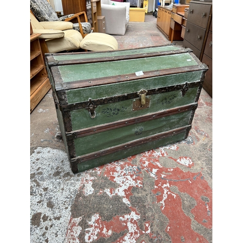 116 - An early 20th century green painted travel trunk with wooden and metal banding