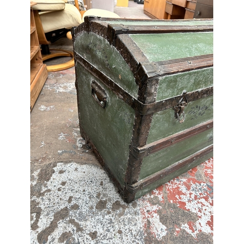 116 - An early 20th century green painted travel trunk with wooden and metal banding