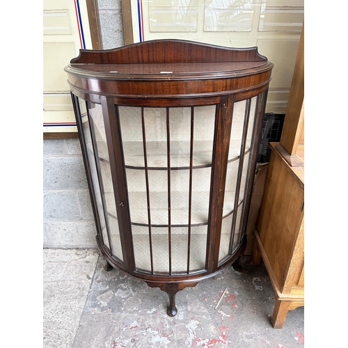 12 - A mahogany bow fronted display cabinet with single glazed door and cabriole supports