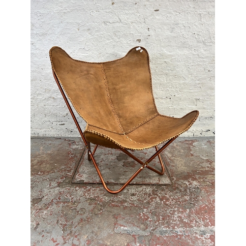 121 - A brown leather butterfly chair