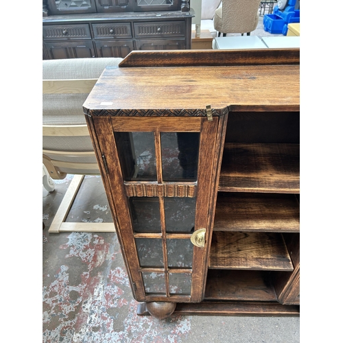 14 - An Art Deco oak bookcase with two glazed doors and baluster supports