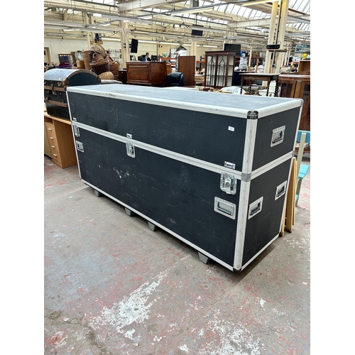 142 - A black plastic and grey metal flight case - approx. 119cm high x 222cm long x 62cm wide