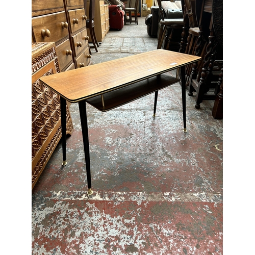 145 - A teak rectangular coffee table with ebonised splayed supports