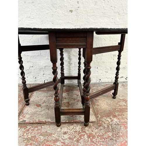 149 - A Macclesfield School of Carving carved oak drop leaf gate leg oval dining table on barley twist sup... 