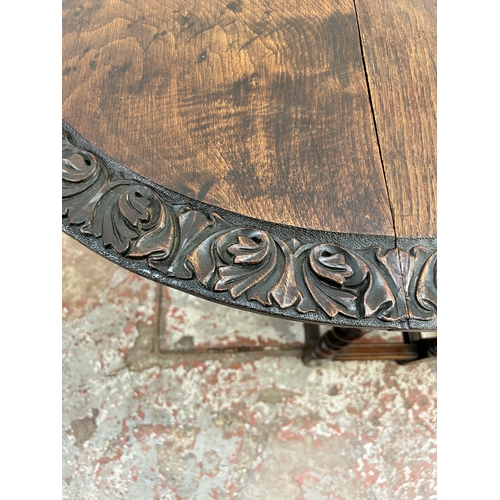 149 - A Macclesfield School of Carving carved oak drop leaf gate leg oval dining table on barley twist sup... 