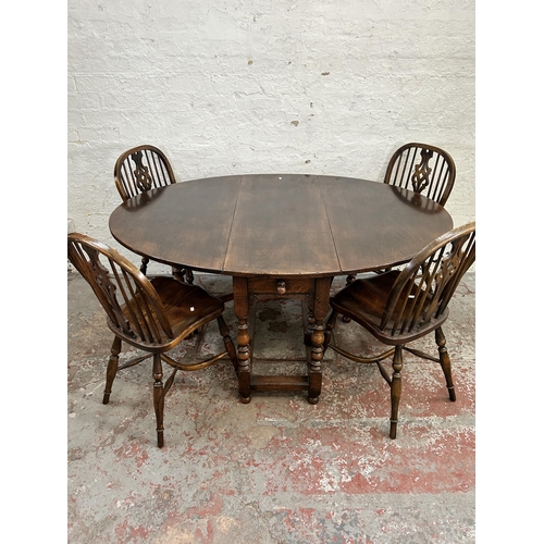150 - A 17th century style carved oak drop leaf gate leg oval dining table and six elm Windsor dining chai... 