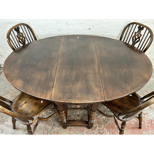 150 - A 17th century style carved oak drop leaf gate leg oval dining table and six elm Windsor dining chai... 
