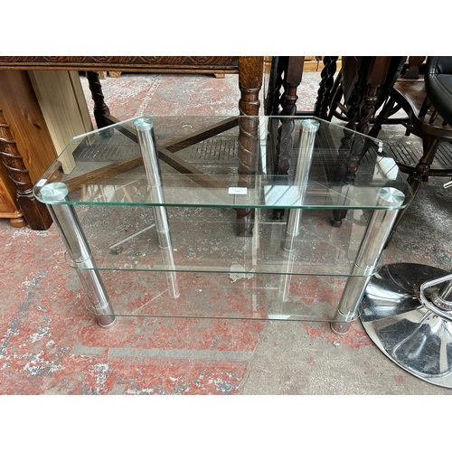 170 - A clear glass and chrome plated three tier TV stand