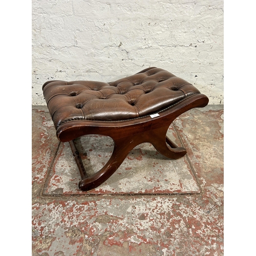 173 - A brown leather and mahogany Chesterfield footstool