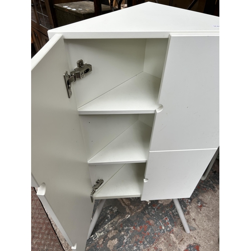 36 - Two pieces of furniture, one white laminate tripod pedestal corner cabinet and one grey painted half... 