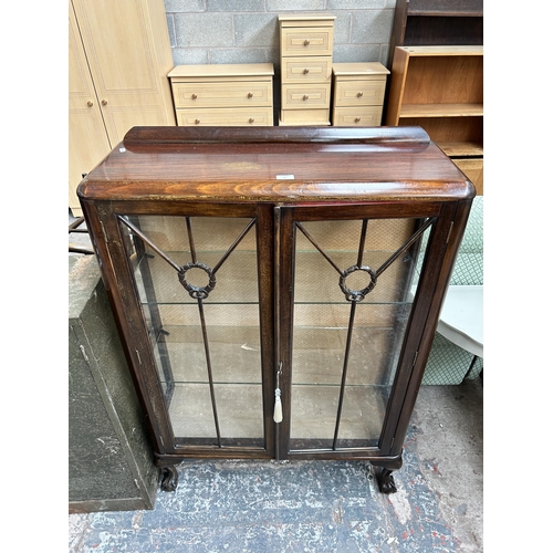 37 - An early 20th century mahogany display cabinet with two glazed doors, two glass shelves and ball and... 