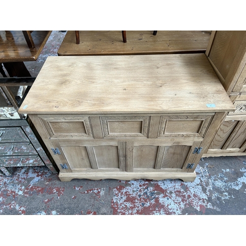 43 - A limed oak sideboard with three drawers and two cupboard doors