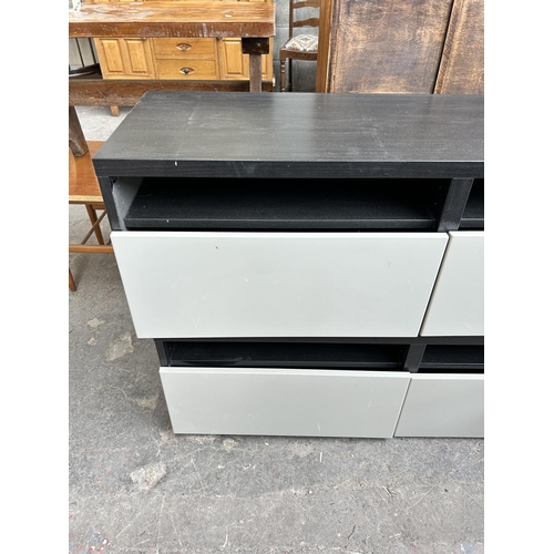 49 - Two modern black ash effect and grey plastic two drawer TV stands - both approx. 120cm wide