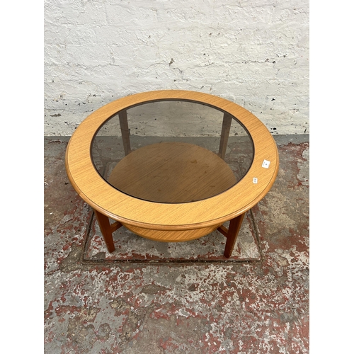 55 - A teak and smoked glass circular two tier coffee table - approx. 40cm high x 76cm diameter