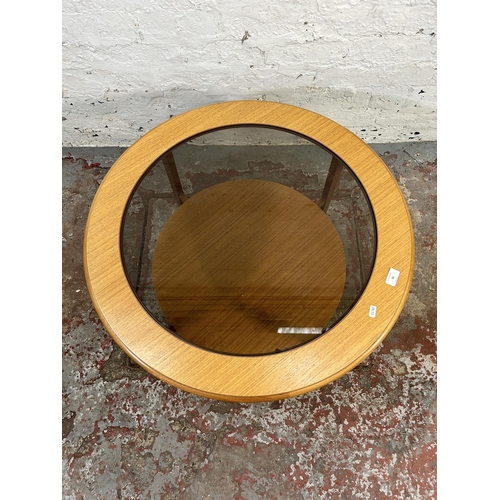 55 - A teak and smoked glass circular two tier coffee table - approx. 40cm high x 76cm diameter