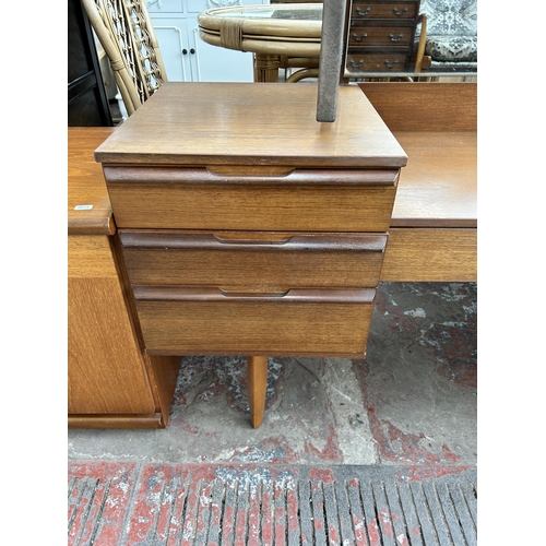 83 - A mid 20th century teak dressing table with seven drawers and upper mirror