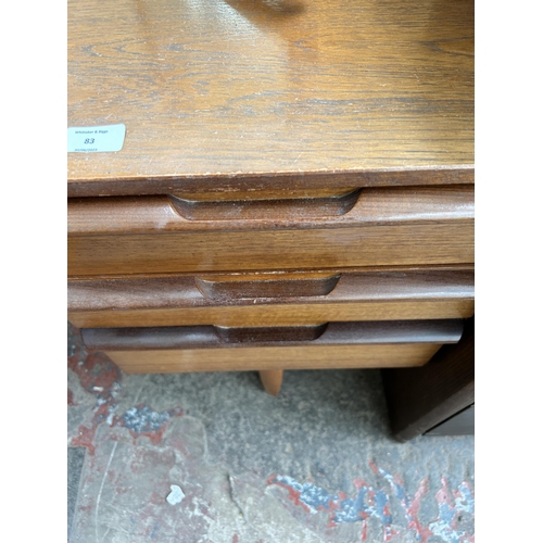 83 - A mid 20th century teak dressing table with seven drawers and upper mirror