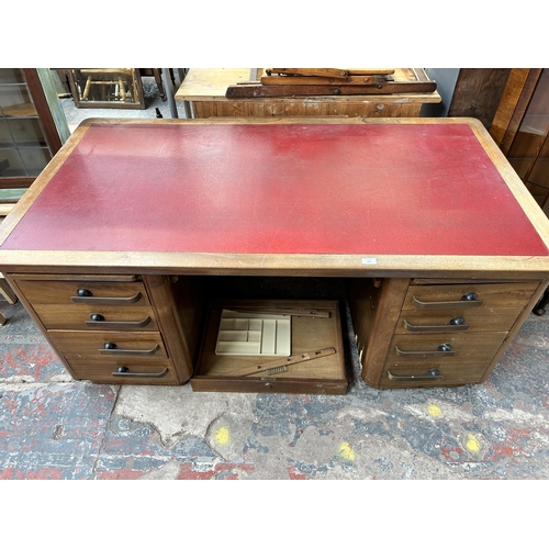 188 - A mid 20th century walnut veneered twin pedestal office desk with seven drawers and red leatherette ... 