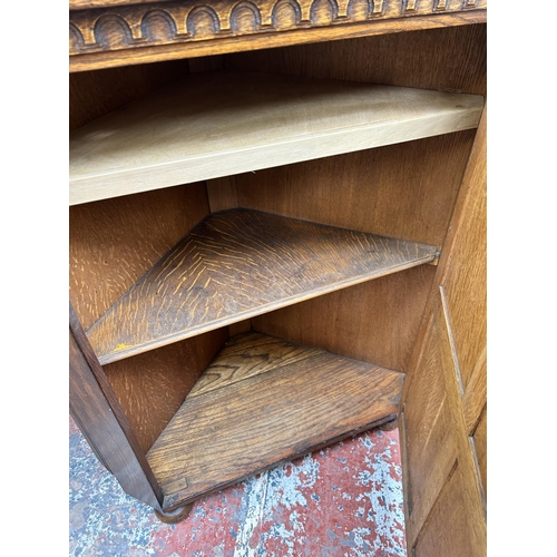 195 - A carved oak corner cabinet