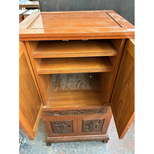 236 - A Chinese carved hardwood stereo cabinet with four cupboard doors and fitted interior