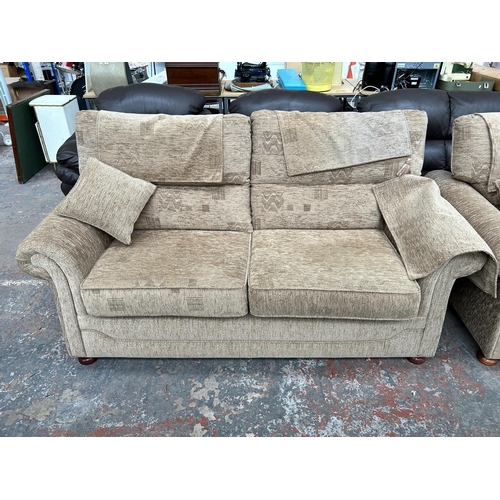 240 - A brown fabric upholstered two piece lounge suite comprising three seater sofa and armchair