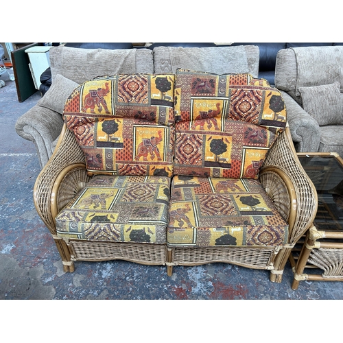 241 - A bamboo and wicker three piece conservatory suite comprising two seater sofa, armchair and rectangu... 