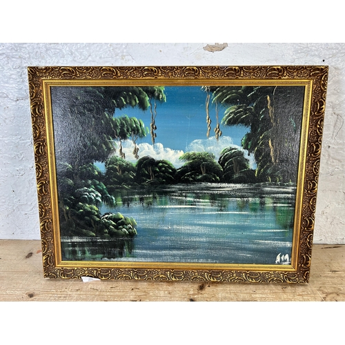 295 - A mid 20th century gilt framed oil on board of a jungle scene - approx. 43cm high x 56cm wide