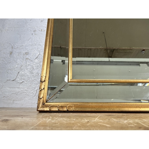 303 - A gilt framed bevelled edge wall mirror - approx. 82cm high x 113cm wide