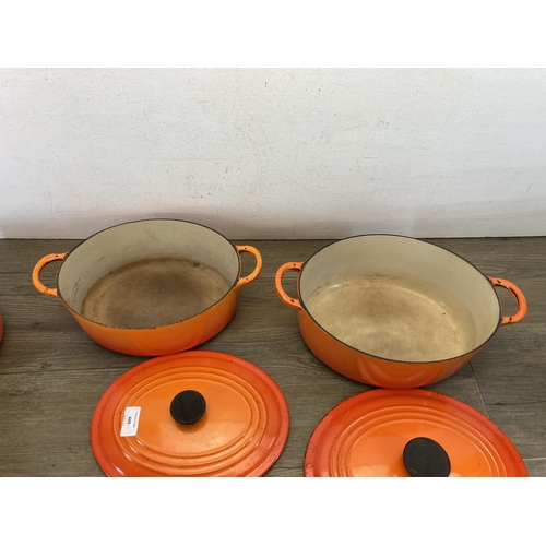 449 - Five pieces of Le Creuset orange enamel and cast iron kitchenware, two casserole dishes and three sa... 