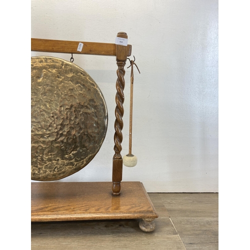 450 - A brass dinner gong on oak barley twist stand with beater - approx. 60cm high x 68cm wide x 25cm dee... 