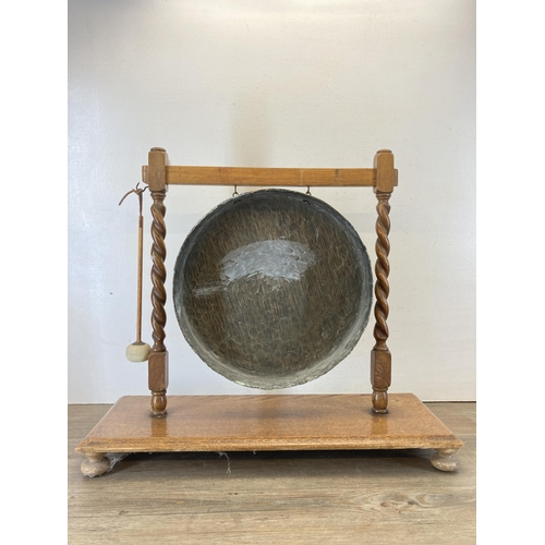 450 - A brass dinner gong on oak barley twist stand with beater - approx. 60cm high x 68cm wide x 25cm dee... 