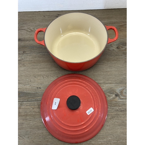 454 - A Le Creuset red enamel and cast iron no. 22 casserole dish