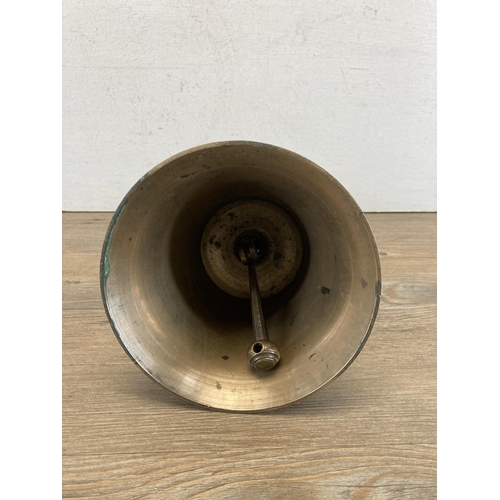 498 - An antique brass hand bell with turned wooden handle - approx. 31cm high