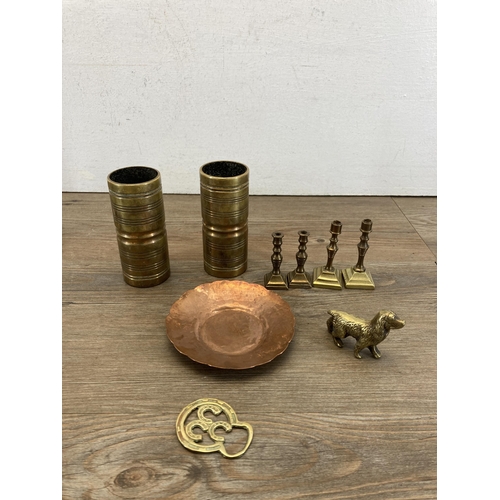 504 - A collection of copper and brassware to include miniature candlesticks, WWII trench art ashtray date... 