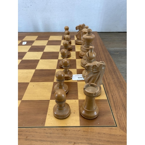 521 - A carved wooden chess set and board