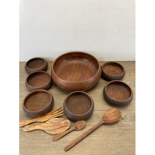 597 - A collection of treenware to include carved teak bowls and dishes, early 20th century inlaid oak and... 